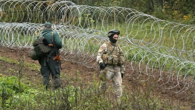 Soldados del ejército letón construyen una valla temporal de alambre de púas a lo largo de la frontera entre Letonia y Bielorrusia, cerca de Robeznieki, Letonia, el 28 de septiembre de 2021.