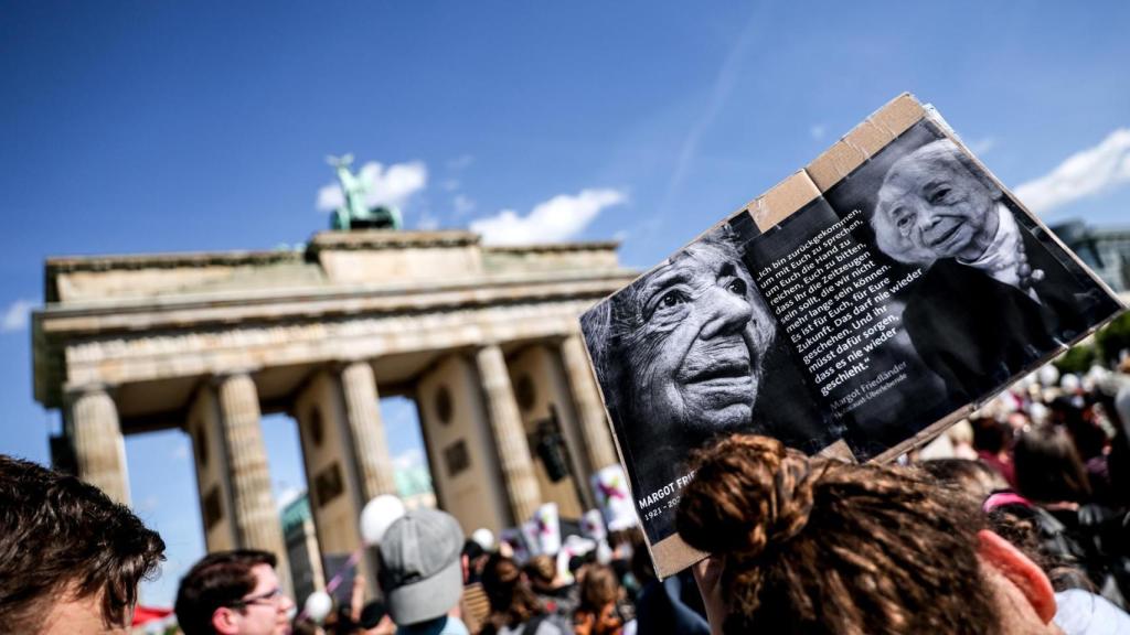 - Una participante sostiene una pancarta con la imagen de la fallecida superviviente del Holocausto Margot Friedländer durante una manifestación que exige la prohibición del partido ultraderechista AfD bajo el lema ¡Basta de excusas! ¡Prohibición de AfD ya!, frente a la Puerta de Brandeburgo en Berlín.