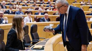 El senador del PP Francisco Bernabé entrega a la vicepresidenta tercera, Sara Aagesen, un saco lleno de estéril minero.