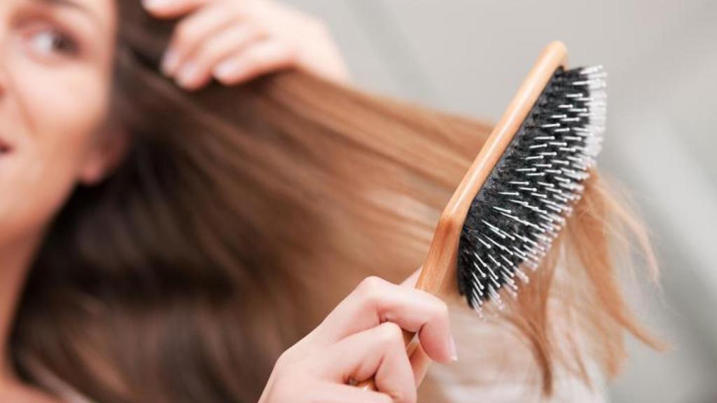 Mujer cepillándose el cabello.