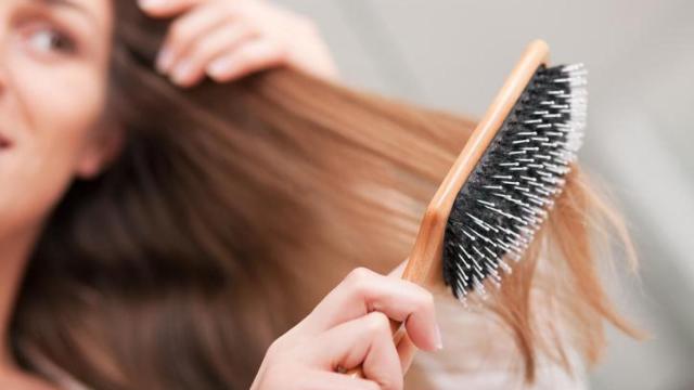 Mujer cepillándose el cabello.