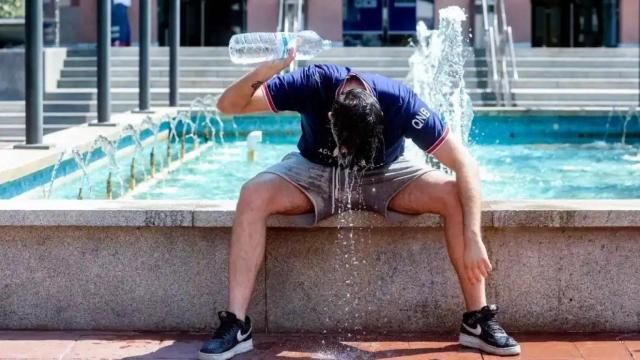 Imagen de archivo de un joven refrescándose durante una ola de calor en España.
