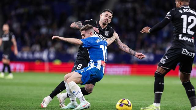 Pol Lozano, del Espanyol, trata de derribar a Miguel de la Fuente.