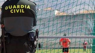 Un agente de la Guardia Civil de espaldas contemplando el campo de fútbol.