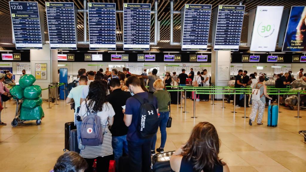 Pasajeros esperan en los mostradores de facturación de su aerolínea en Barajas.