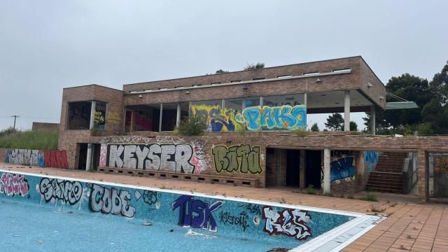 Vecinos de la urbanización posan ante la entrada de las instalaciones deportivas abandonadas de Montegolf, en A Coruña
