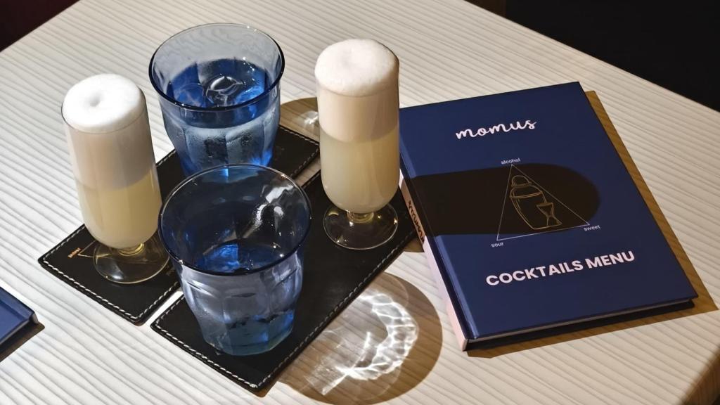 La nueva carta de Momus Bar junto al cóctel 'Jasmine Moustache'.