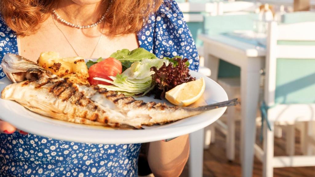 Una mujer come pescado