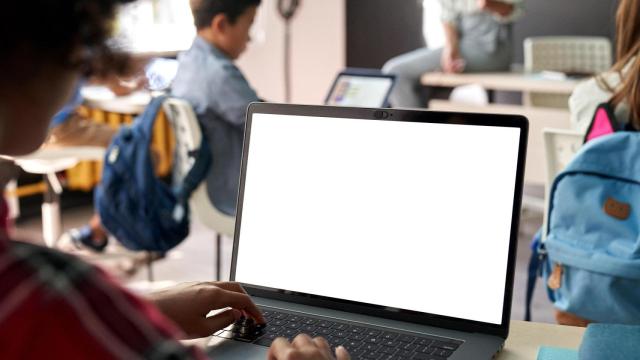 Estudiantes con un ordenador en clase.