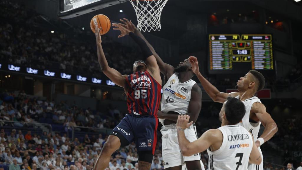 Chima Moneke entra a canasta ante la presión de varios jugadores del Real Madrid.