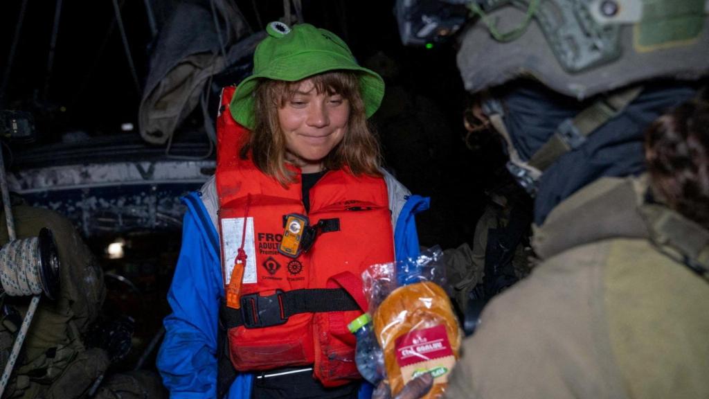 Un soldado israelí entrega un bocadillo a Greta Thunberg.