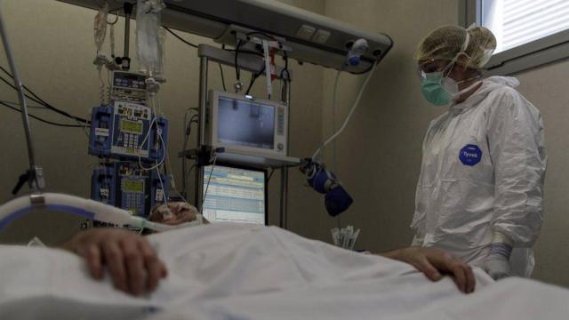 Personal sanitario totalmente protegido atiende a un paciente ingresado en la Unidad de Cuidados Intensivos