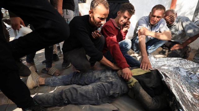 Familiares junto al cadáver de un palestino muerto por un ataque de Israel en Gaza el 11 de junio.