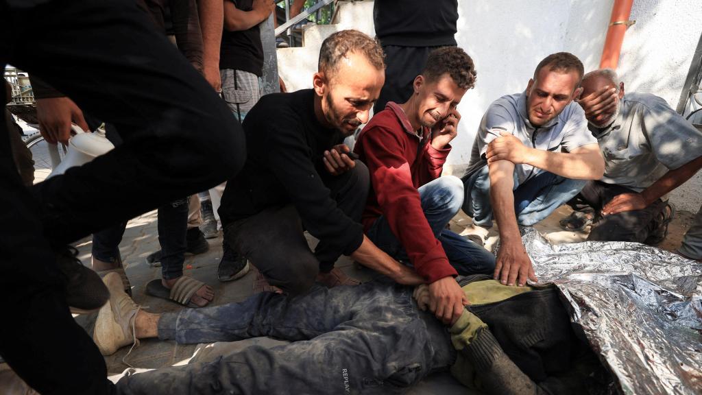 Familiares junto al cadáver de un palestino muerto por un ataque de Israel en Gaza el 11 de junio.