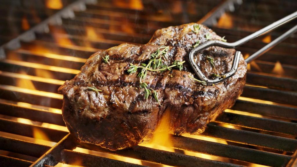 Un filete cocinado en una parrilla sobre el fuego