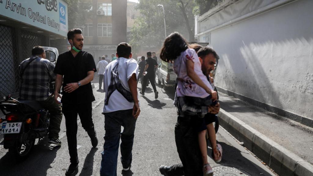 Un grupo de gente corre por la calle tras un ataque de Israel, en Teherán.
