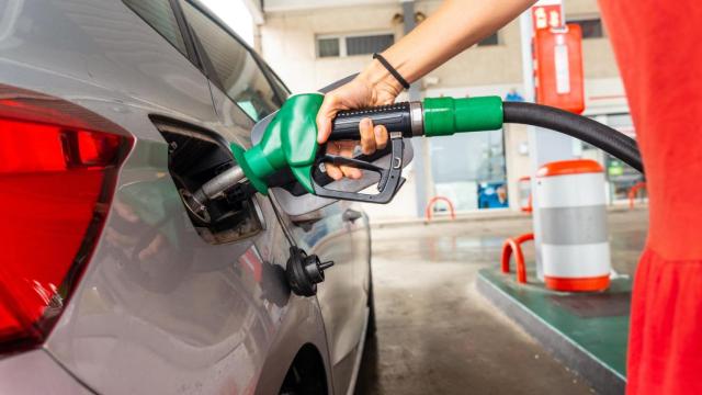 Una mujer echando gasolina en su coche