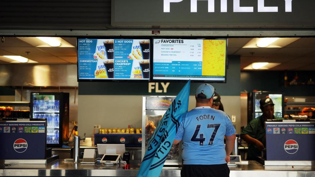 Un aficionado del Manchester City en un puesto de comida en el interior del estadio.