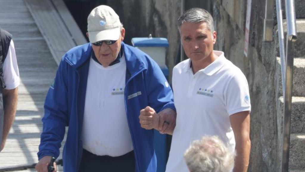 El rey Juan Carlos, ayudado por una escolta, a su llegada a las regatas de Sanxenxo, el 21 de junio.