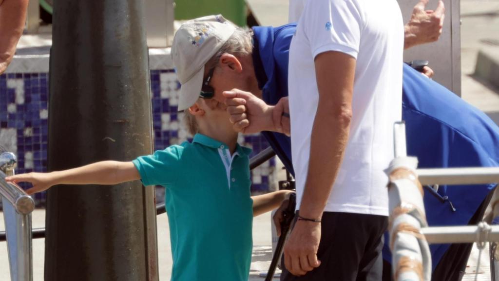 El rey Juan Carlos se inclina para recibir un beso de su ahijado y sobrino Nieto Carlos, hijo de María Zurita.