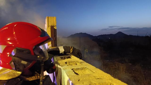 Un bombero del Consorcio de Extinción Incendios y Salvamento (CEIS) comprueba el interior del solar quemado en La Unión (Murcia).