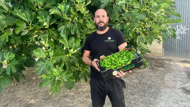 Raúl Gómez posando con los pimientos de su cooperativa