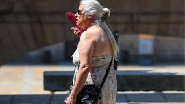Imagen de una mujer abanicándose.