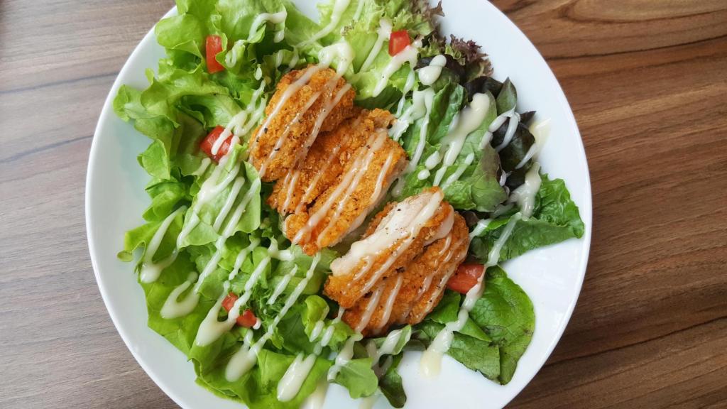 Una ensalada aliñada con salsa.