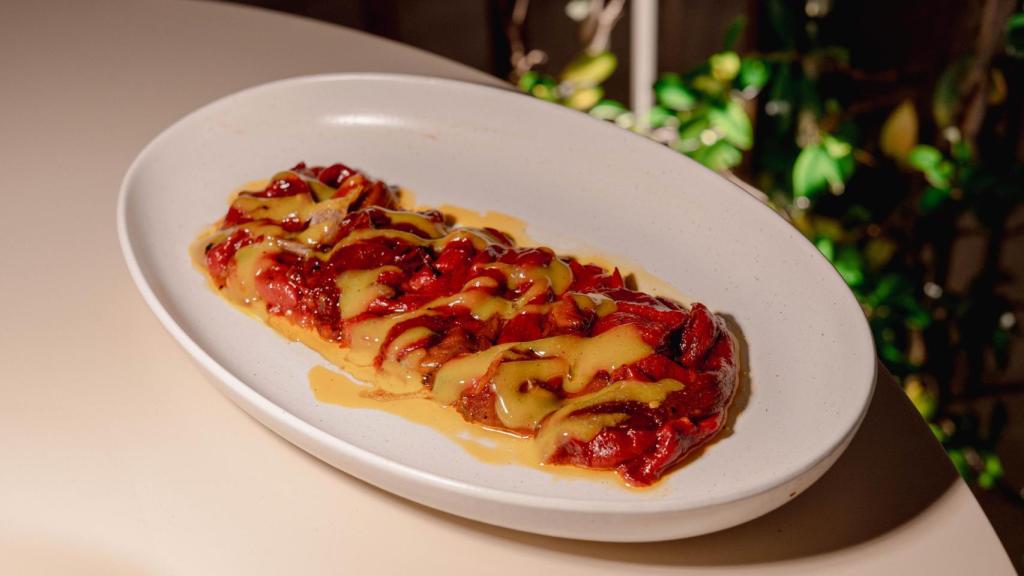 Pimientos rojos triple cocción con yema de huevo cremosa y ajos confitados.