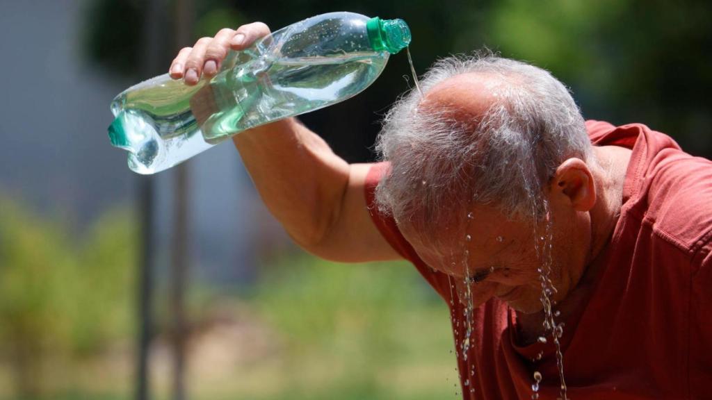 Un hombre se refresca con agua de una botella en la calle en Córdoba el pasado martes.