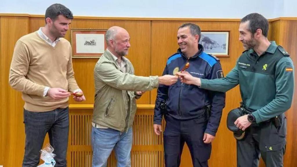 El responsable de la siniestra policía rusa, Sergey Levoshin, entregando una cuchara al teniente en funciones de la Benemérita en Estrada, Eloy Balo, en compañía del responsable de la Policía local, Javier García.