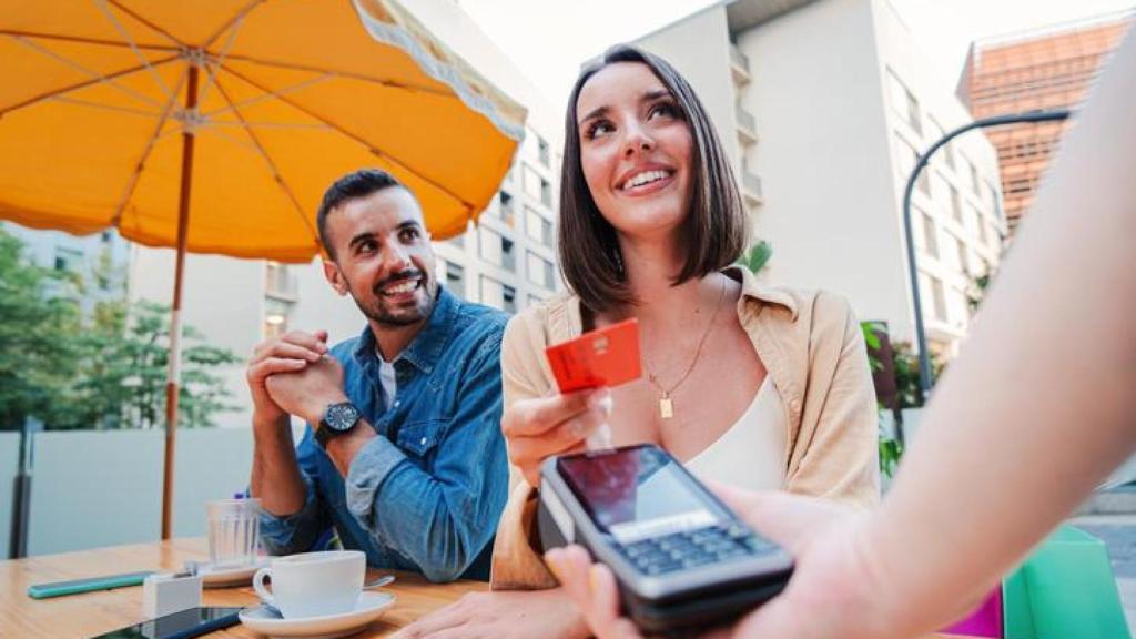 Pareja pagando en una terraza.