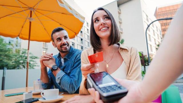 Pareja pagando en una terraza.