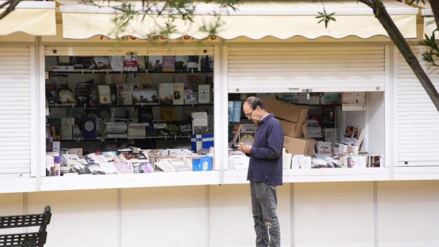 Una persona junto a las casetas de la Feria del Libro de Sevilla de 2024.