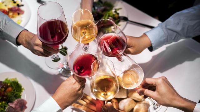 Varias personas brindando con vino