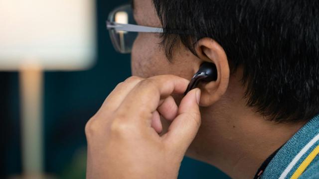 Imagen de archivo de una persona colocándose un auricular.