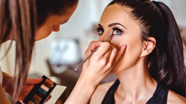 Profesional maquillando los ojos de una mujer.