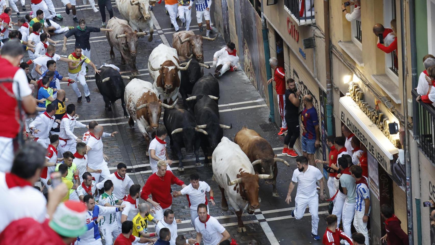 Los mozos son perseguidos por toros de la ganadería gaditana de La Palmosilla s durante el séptimo encierro de los Sanfermines 2025 este domingo en Pamplona.