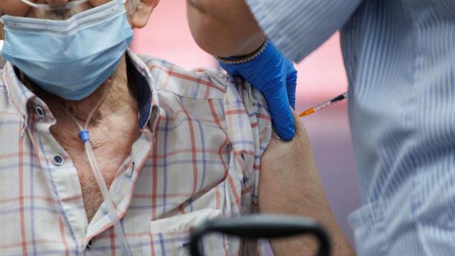 Un enfermero vacuna a un anciano en una residencia