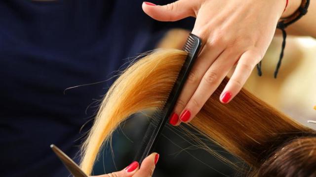 Peluquera cortando el pelo.