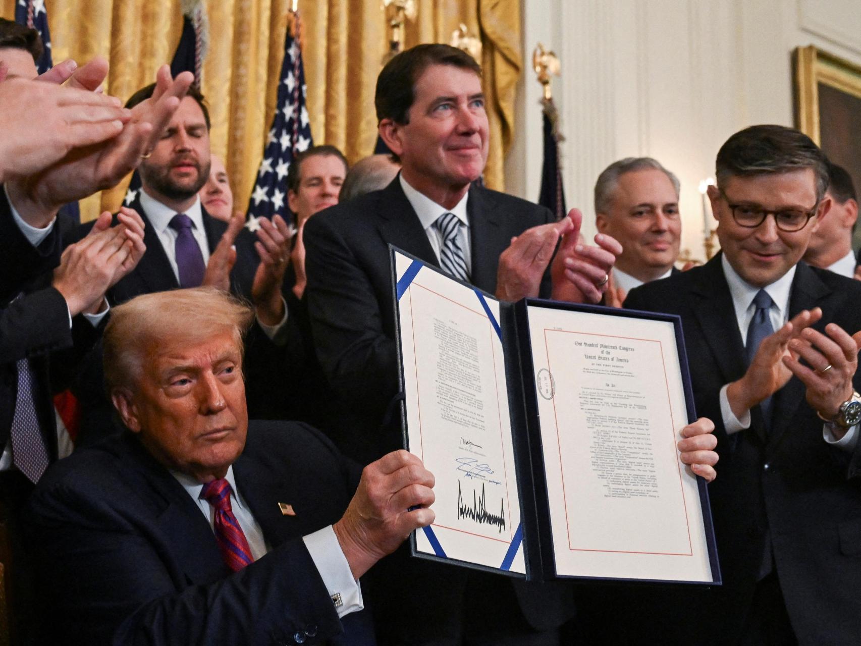 El presidente de Estados Unidos, Donald Trump, sostiene la Ley Genius firmada, que desarrollará un marco regulatorio para las criptomonedas stablecoin y ampliará la supervisión de la industria, en la Casa Blanca en Washington, D.C., Estados Unidos, 18 de julio de 2025.