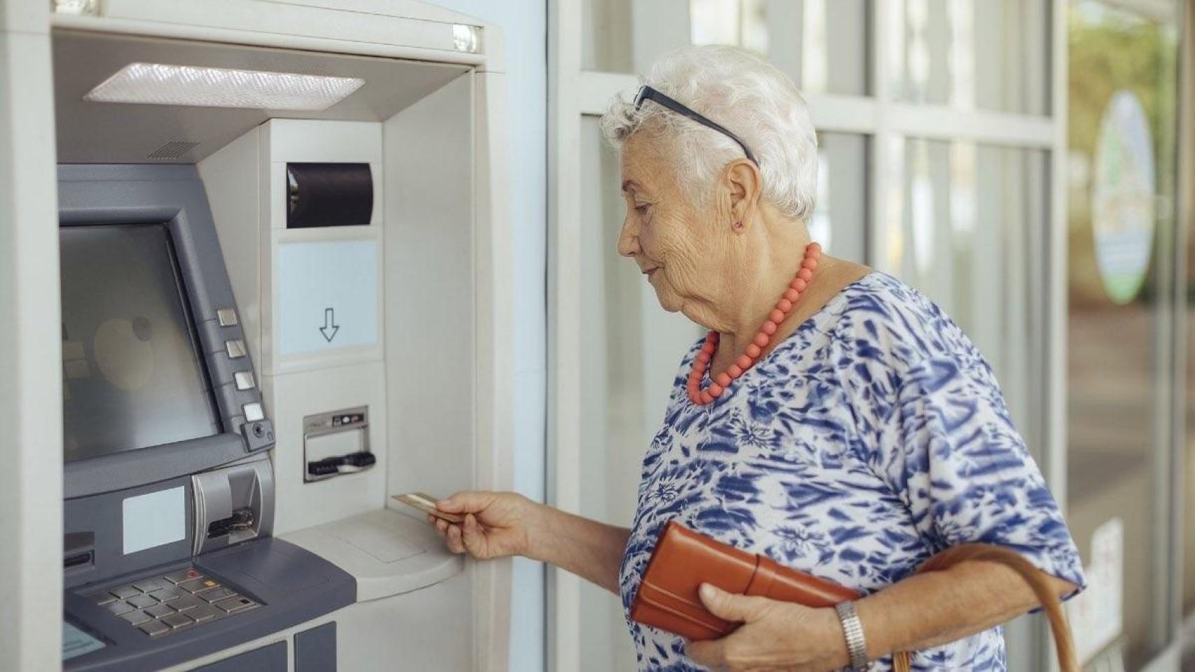Una mujer sacando dinero de un cajero automático.