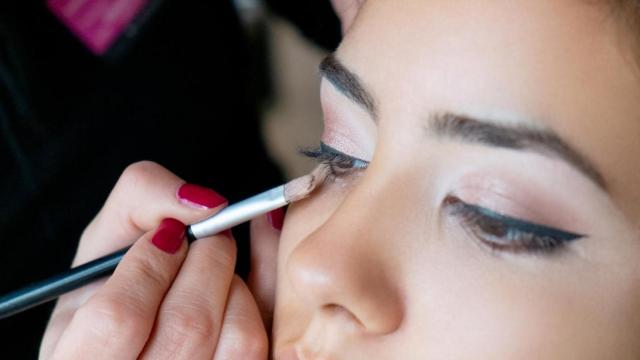 Imagen de una mujer pintándose los ojos.