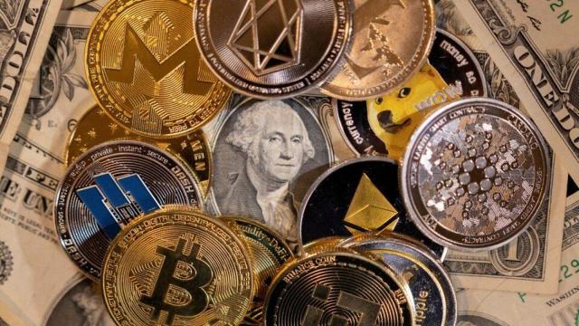 Varias criptomonedas sobre billetes de dólar.