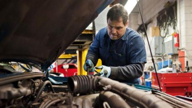Imagen de un mecánico arreglando un motor.