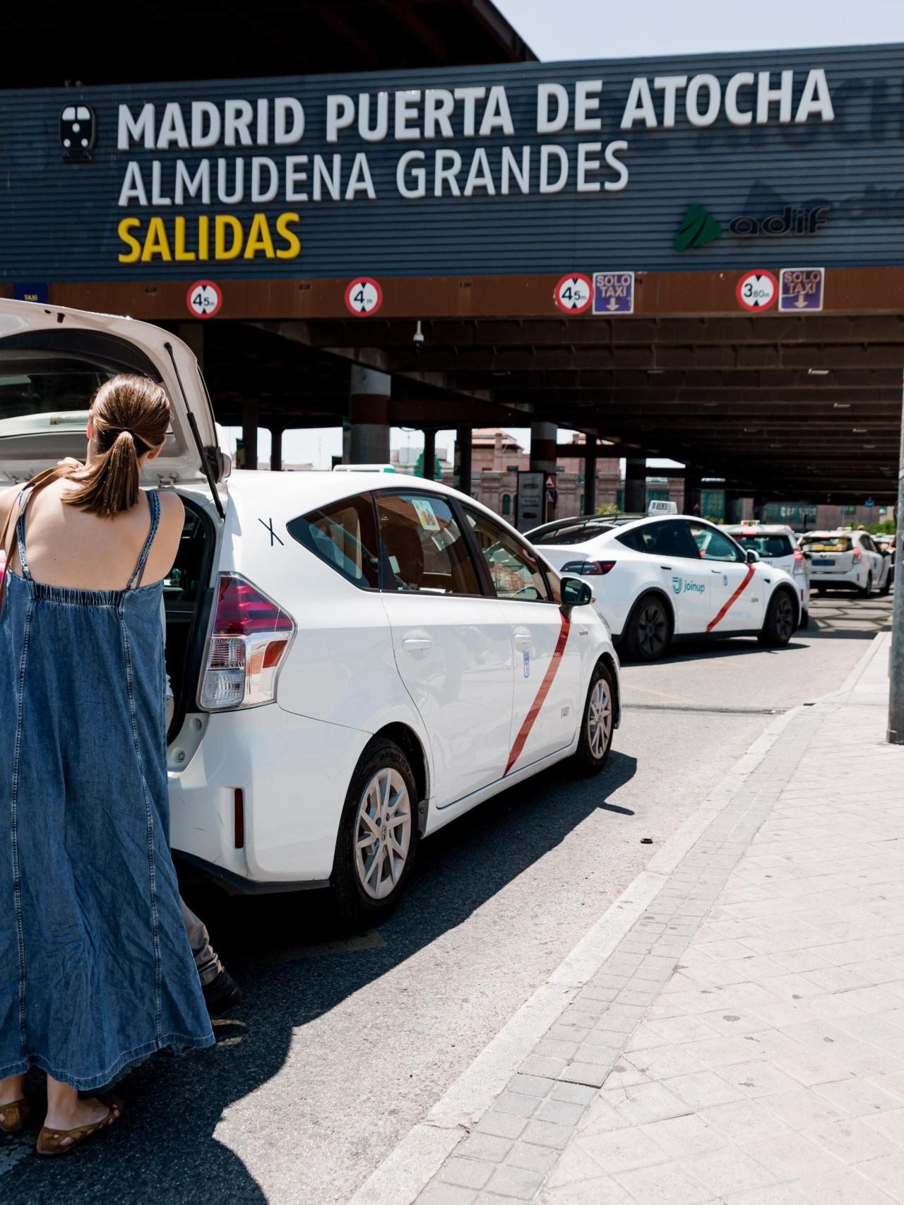 Unas mujeres cargan su equipaje en un taxi en la estación de Atocha de Madrid.