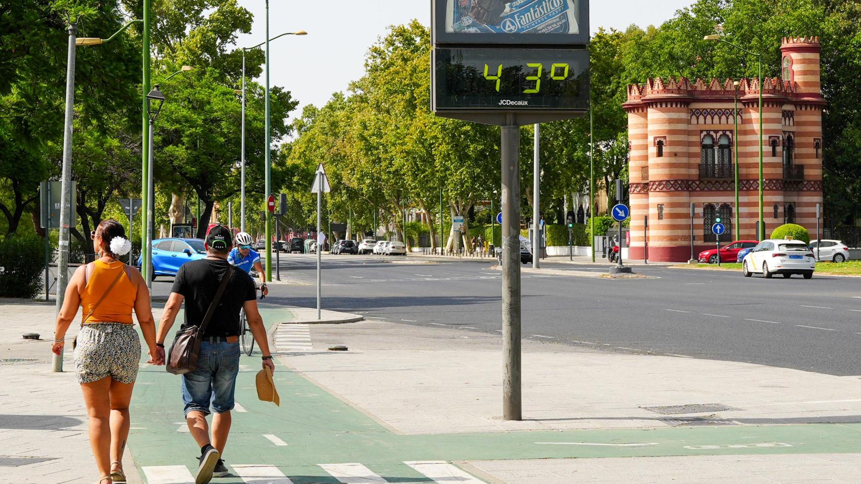 Imagen de una pareja paseando por Sevilla junto a un termómetro que marca 43º.