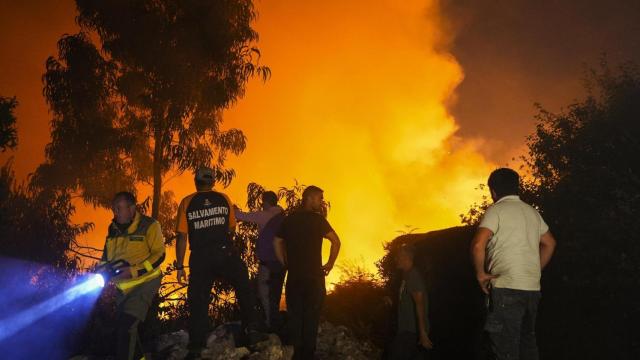 Varias personas tratan de extinguir el fuego, a 5 de agosto de 2025, en Ponteceso, A Coruña