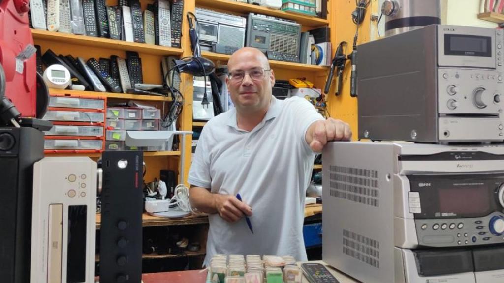 Roberto Martí Pombo, entre aparatos electrónicos en su bajo de reparación de la calle Galera.