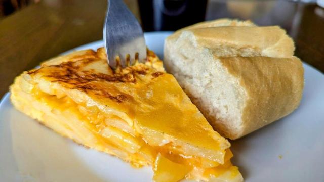 Un pincho de tortilla de patata con un trozo de pan en un bar.